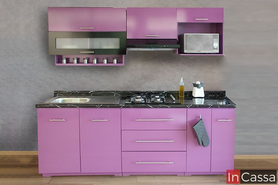 Este elegante conjunto de cocina integral en color uva con cubierta de fomaica en estilo mármol negro, presenta una distribución compacta y funcional. Incluye gabinetes superiores e inferiores, espacio para microondas, estufa y fregadero, todo con un acabado moderno y brillante.