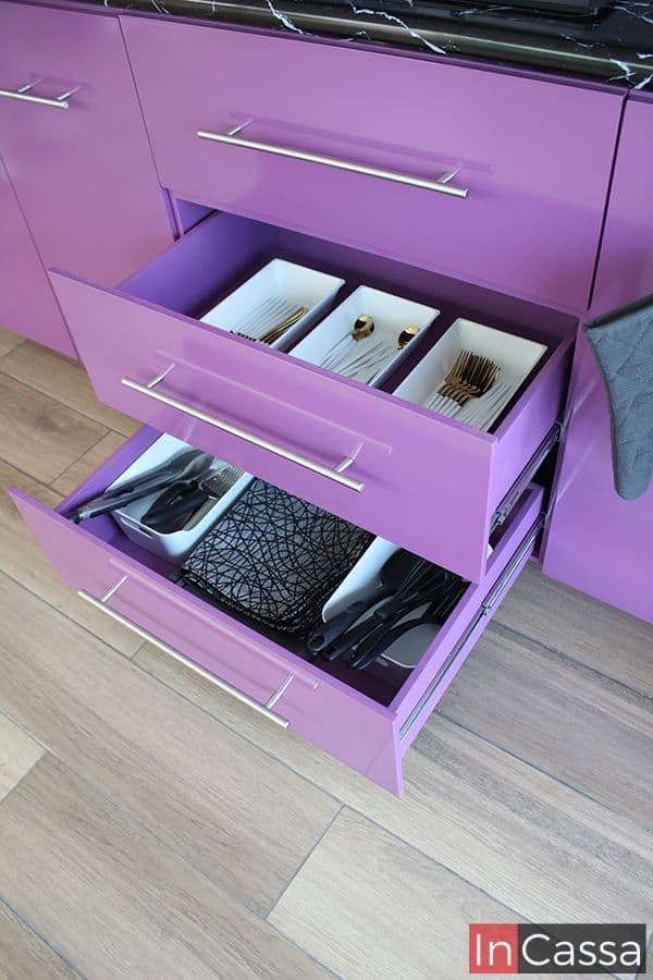 Estos cajones en color uva completo ofrecen un amplio y organizado espacio de almacenamiento para cubiertos y utensilios de cocina. Con un diseño moderno y tiradores metálicos, complementan la estética y funcionalidad del conjunto de cocina, maximizando el uso eficiente del espacio.