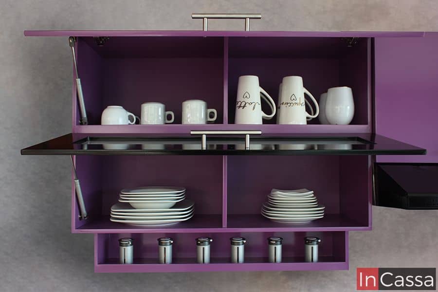Este gabinete superior en color uva cuenta con un diseño práctico y moderno. Ofrece almacenamiento dividido en secciones para platos y tazas, además de un especiero integrado en la parte inferior, optimizando el espacio de la cocina.