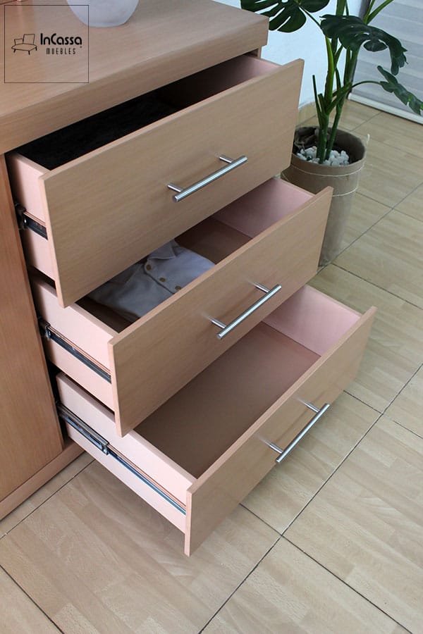 La toma lateral muestra los tres cajones del tocador Croacia en acabado natural, completamente abiertos para destacar su amplitud interior, jaladeras metálicas y correderas de extensión que facilitan un uso cómodo y eficiente.