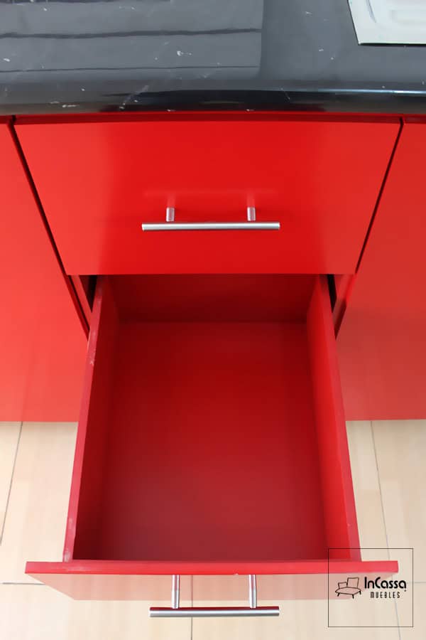 La imagen muestra uno de los cajones de la cocina roja, diseñado con un sistema de deslizamiento suave y de fácil acceso, perfecto para almacenar cubiertos y utensilios.