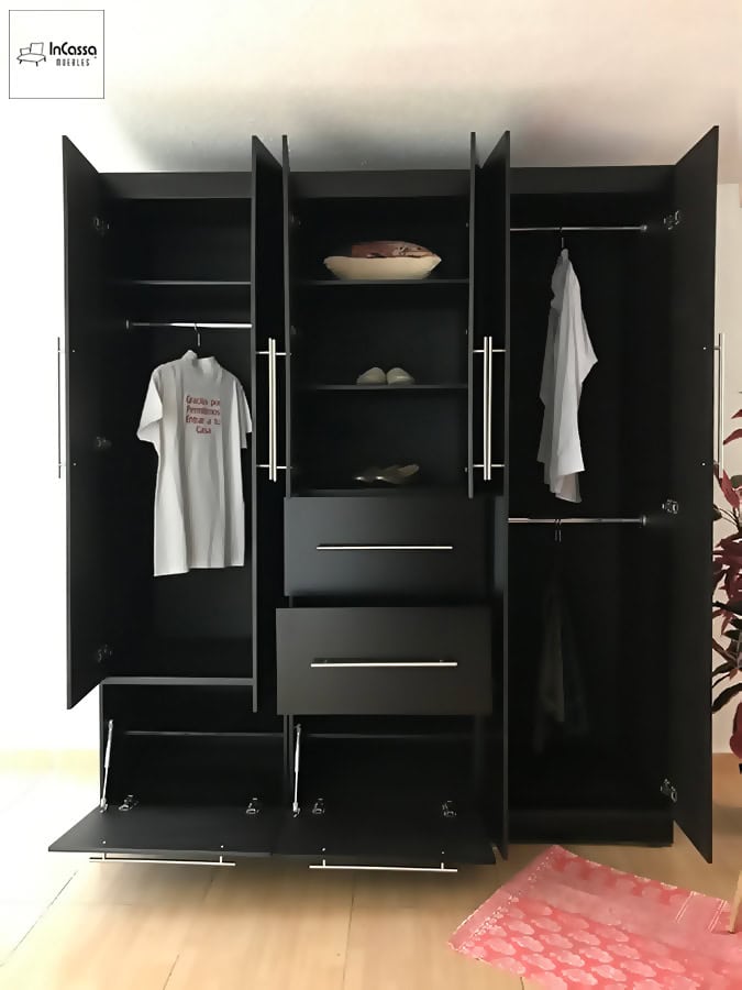 La foto muestra el clóset con todas sus puertas y compartimentos abiertos, dejando a la vista sus interiores los cuales conservan el mismo color chocolate que las partes exteriores del mueble, y en los que además se hace uso de algunas prendas y accesorios para ejemplificar la capacidad de cada espacio.