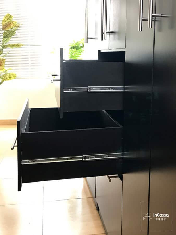 Toma lateral del clóset que se enfoca en destacar la estructura completa de cada cajón, los cuales están pintados en color chocolate (al igual que el resto del mueble), y que además cuentan con rieles metálicos integrados para su sistema de apertura y cierre.