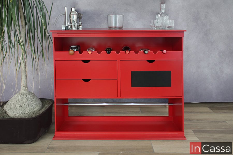 Podemos observar la parte trasera de la barra cantina, la cual cuenta con cava incorporada, dos cajones y un compartimento adicional. Esta parte es de color rojo al igual que el frente de la cantina, además de un parche negro decorativo en la puerta del compartimento.