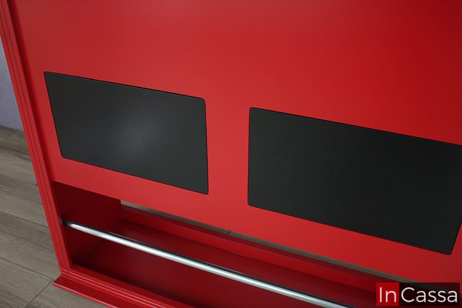 Vemos con más detalle los parches negros decorativos incluidos en este diseño. Además de que también se puede ver la barra posa pies metálica incluida en la cantina, misma que mantiene un tono rojo completo en su estructura.