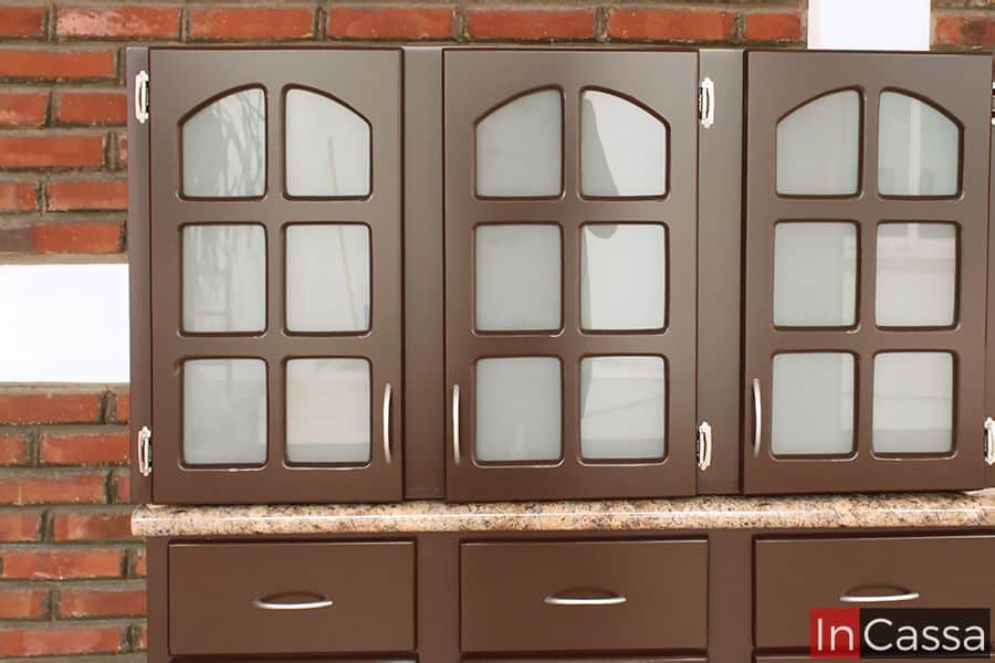 Imagen de la alacena superior en acabado café completo, con un diseño de puertas en vidrio esmerilado y cuadrículas arqueadas, combinan estilo y funcionalidad. Las manijas de acero inoxidable aseguran un fácil acceso, mientras que los espacios interiores son ideales para organizar tus artículos de cocina con elegancia.