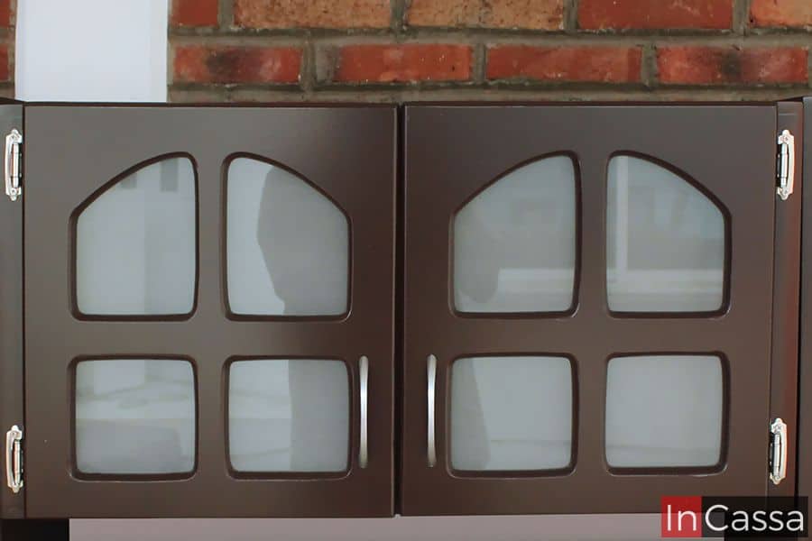 Mueble sobre campana en acabado café completo con puertas de vidrio esmerilado y diseño de cuadrícula arqueada, que aportan un estilo clásico y elegante. Las manijas de acero inoxidable añaden un toque moderno y funcional.