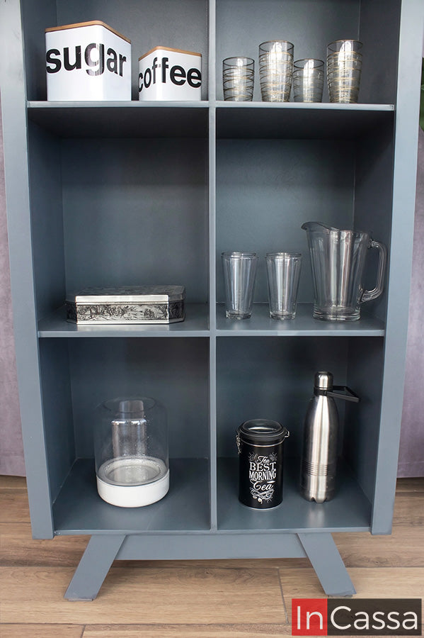 Un acercamiento inferior resalta los compartimentos de la vitrina en color gris oxford, mostrando su capacidad de almacenamiento para cristalería y accesorios; su diseño uniforme y acabado elegante aportan orden y estilo en cada detalle.