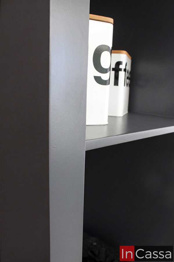 Una toma de detalle lateral destaca el acabado en color gris oxford, con superficies lisas y líneas definidas que reflejan su estilo minimalista; su estructura sólida y bien terminada aporta durabilidad y un toque sofisticado al ambiente.