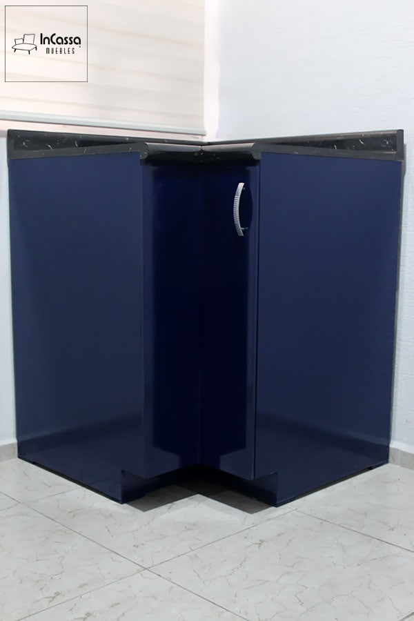 Fotografía del módulo esquinero de cocina Italia en color azul marino brillante, con cubierta de formaica superior tipo mármol negro y jaladera metálica curva. La toma frontal resalta su diseño compacto y elegante, ideal para aprovechar esquinas y aportar un toque moderno al espacio.