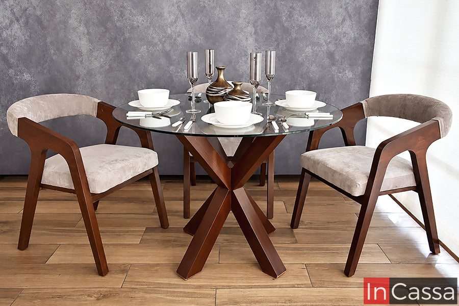 Como protagonista de su diseño, la base geométrica distingue al Comedor Redondo Viral en Pinterest FORMENTERA con Mesa de Vidrio en color tabaco con sillas tapizadas en suede gris perla. La cubierta transparente permite apreciar su estructura y las líneas curvas que caracterizan a cada silla.
