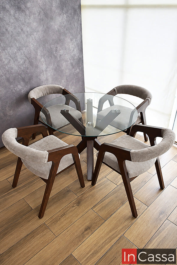 Vista en conjunto, la distribución del Comedor Redondo Viral en Pinterest FORMENTERA con Mesa de Vidrio resalta su estructura en color tabaco y sus sillas tapizadas en suede gris perla. La cubierta circular transparente permite observar la original base de la mesa y la armonía entre sus cuatro sillas.
