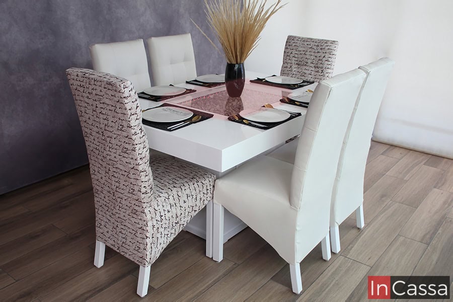 Una toma del comedor blanco en su presentación de 6 sillas tapizadas, en el que vemos su arenero con iluminación LED roja. La mesa está adornada con unas cuantas vajillas y utensilios, y una planta decorativa como centro de mesa.