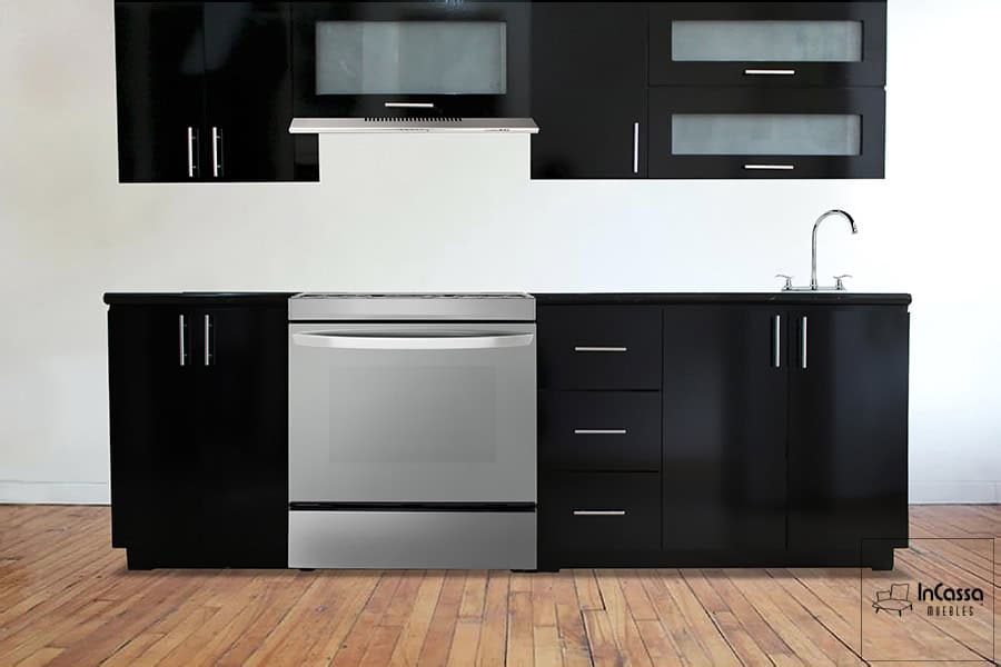 Una toma de la cocina integral en elegante color negro resaltando su diseño moderno. Presenta alacenas con puertas de vidrio esmerilado, cajones espaciosos, gabinetes inferiores y área para estufa y tarja. Su acabado brillante y jaladeras metálicas realzan su estilo sofisticado.