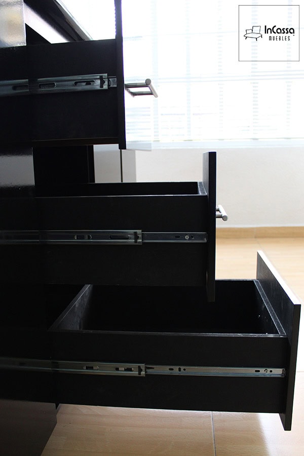 Se presenta un módulo con cajones en acabado negro, cada uno con correderas metálicas de extensión para un deslizamiento suave. Su diseño profundo permite almacenar utensilios y accesorios de cocina con facilidad. Las jaladeras metálicas añaden un toque moderno y funcional al conjunto.