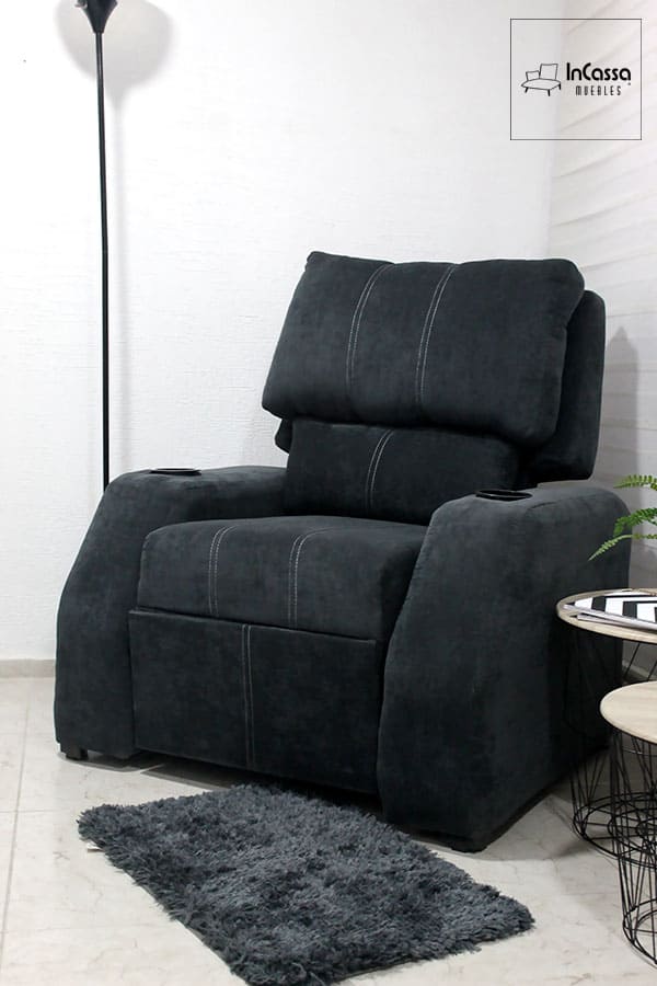 La foto nos presenta el sillón reposet desde una toma frontal, en la que vemos de manera completa el respaldo del mueble y gran parte de su estructura. Por la cercanía de la toma, es posible apreciar mejor el tapizado del sillón en tela suede además de sus costuras.