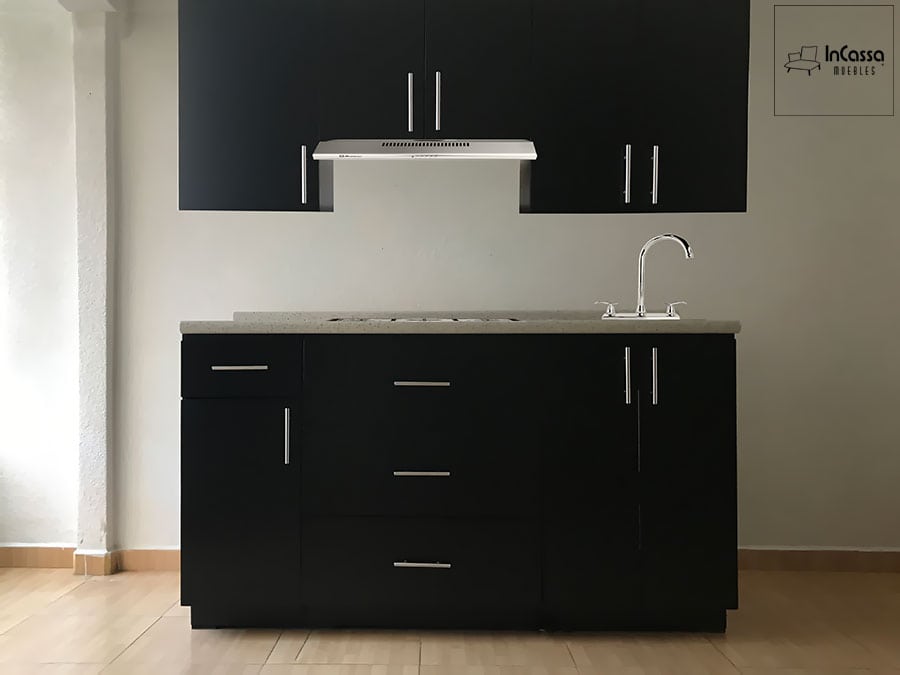 Moderna cocina con gabinetes superiores e inferiores en acabado chocolate mate, complementados con elegantes jaladeras metálicas. La cubierta de formaica ofrece un espacio de trabajo amplio y resistente. Diseño minimalista y funcional.