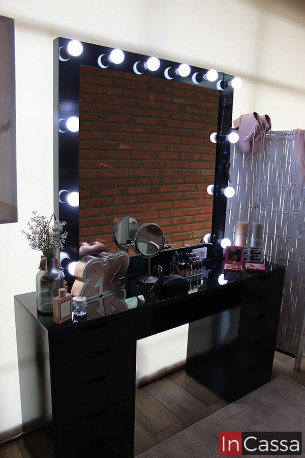 En esta toma más cercana podemos apreciar el brillo de los focos LED, los cuales resaltan el acabado brillante en la pintura color negro, además de la gran cantidad de utensilios que pueden colocarse en la cubierta del tocador.