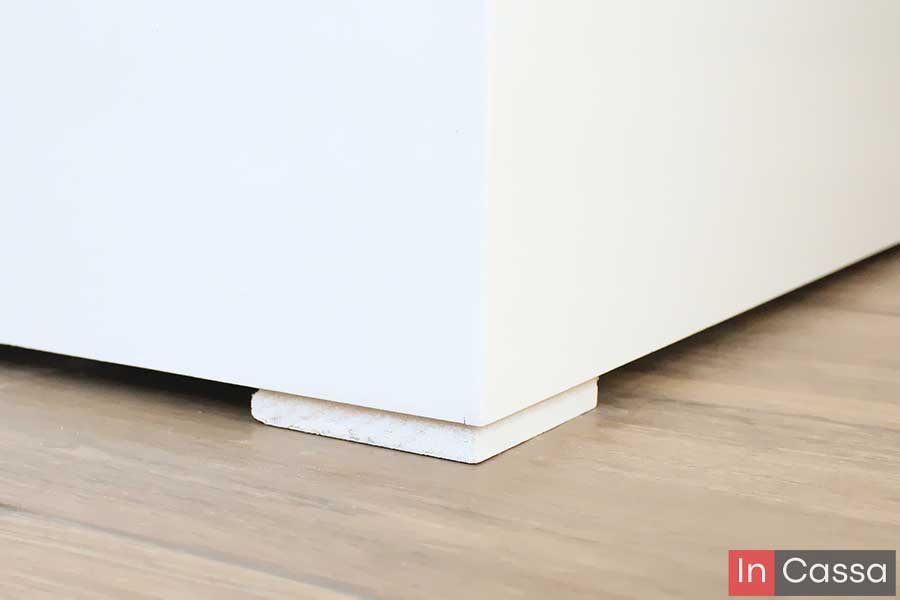 Esta imagen destaca el diseño oculto de las patas de la base, elaboradas en un tono blanco que se integra perfectamente al resto del mueble, ofreciendo soporte firme, discreción estética y protección para el piso.