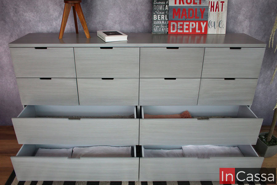 La imagen muestra la cajonera con sus 4 cajones inferiores abiertos, los cuales son visiblemente más amplios que los compartimentos superiores y en su interior mantienen un tono gris similar al de las partes exteriores del mueble.