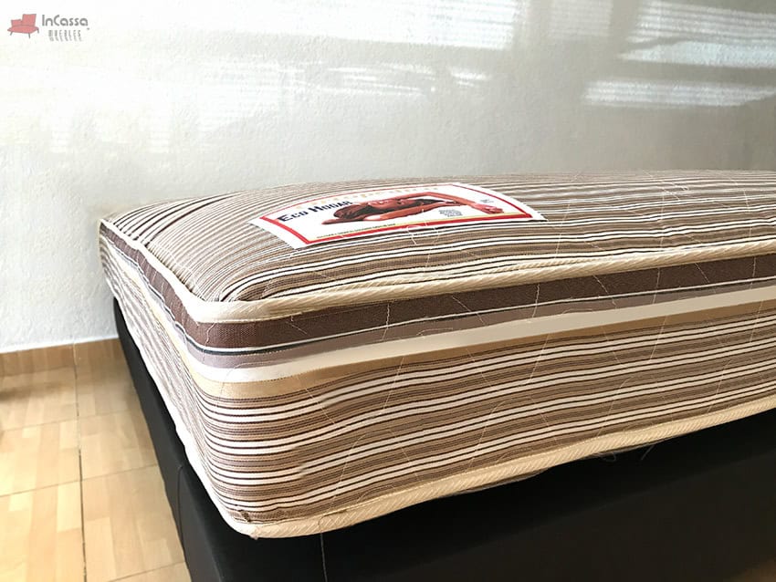 La foto nos enseña mejor el grosor del colchón que, gracias a la base en la que se presenta, podemos ver qué es bastante considerable. Al igual que con el acolchonado y los bordes, en esta toma es posible ver parcialmente la etiqueta de presentación.