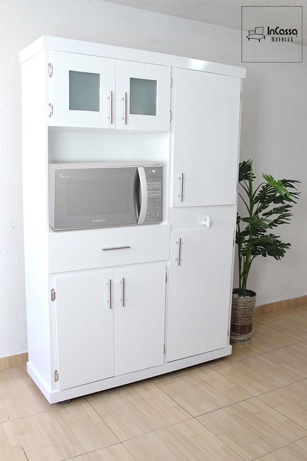 La imagen muestra la Alacena para Microondas Modelo HOUSTON, en elegante acabado blanco brillante con jaladeras metálicas. Su diseño moderno incluye compartimentos superiores con puertas de cristal esmerilado, espacio central para microondas y amplios gabinetes inferiores que ofrecen gran capacidad de almacenamiento.