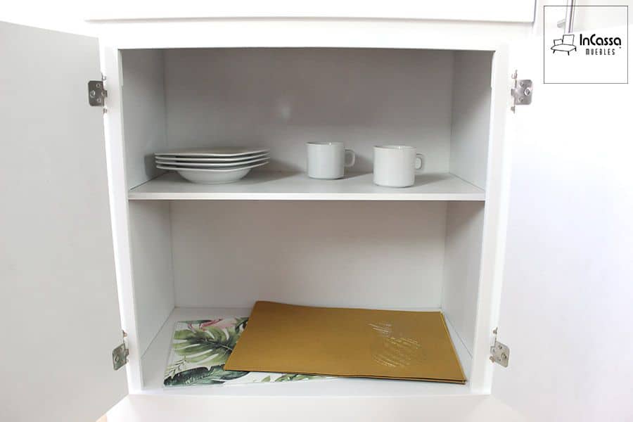 La imagen muestra una vista frontal del módulo inferior abierto de la Alacena para Microondas Modelo HOUSTON, destacando su amplio espacio de almacenamiento con entrepaño central. En su interior se observan vajillas y tazas distribuidas de forma ordenada, resaltando la funcionalidad y el acabado blanco brillante que facilita la limpieza y aporta un aspecto moderno a la cocina.