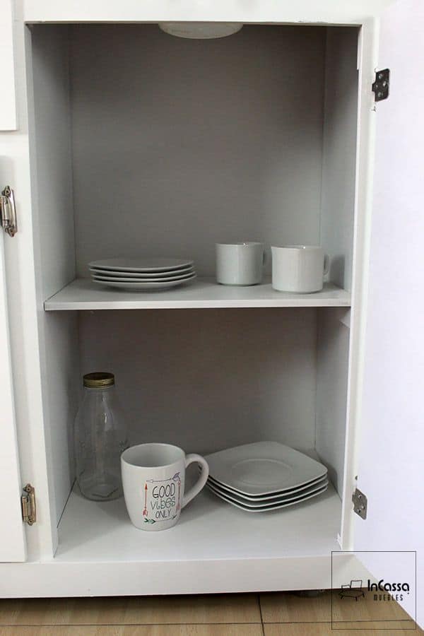 En esta fotografía se observa el compartimento lateral de la Alacena para Microondas Modelo HOUSTON, con dos amplios entrepaños que permiten organizar tazas, platos o frascos de cocina. El acabado blanco brillante maximiza la sensación de limpieza y luminosidad, mientras que las bisagras metálicas garantizan resistencia y un cierre suave para un uso diario duradero.