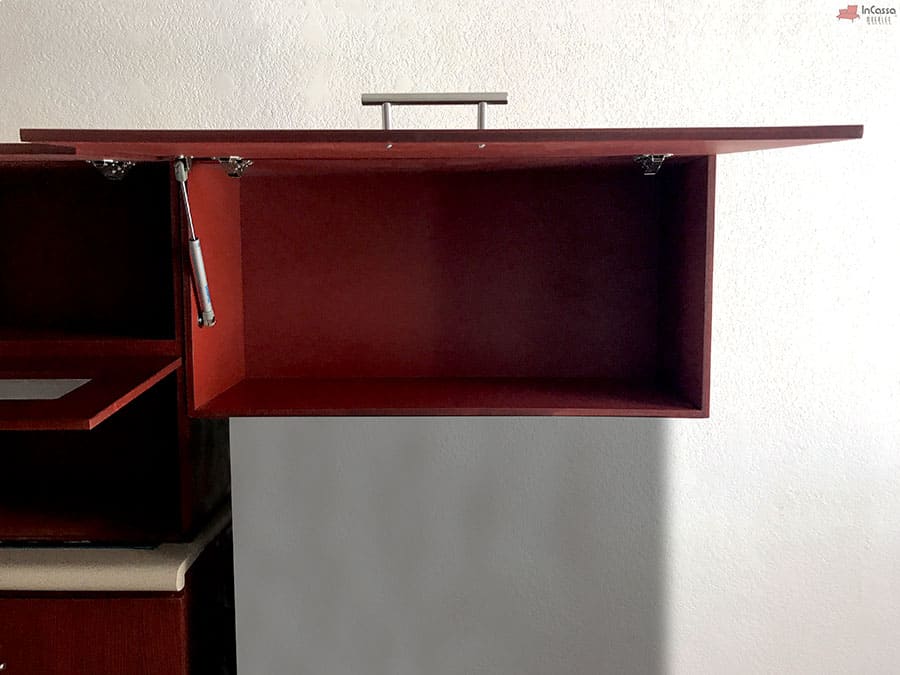 Una fotografía del módulo superior en acabado maple oscuro completo de la cocina integral con la puerta abierta. Este compartimento, sostenido por pistones de neumáticos, ofrece un espacio amplio y accesible, ideal para almacenar utensilios o alimentos. Su diseño garantiza comodidad y funcionalidad al mantener la puerta en posición abierta de manera segura.