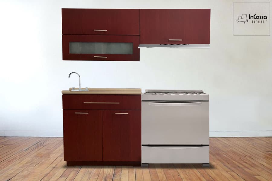 La imagen muestra un diseño compacto y funcional de cocina integral en acabado maple oscuro. Incluye gabinetes superiores con acabado moderno, uno de ellos con vidrio esmerilado, perfectos para almacenar vajilla y utensilios. En la parte inferior, los gabinetes y cajones amplían el espacio de organización, integrando una tarja de acero inoxidable y una cubierta de madera que resalta el estilo contemporáneo. Su diseño es ideal para optimizar espacios pequeños sin sacrificar elegancia.