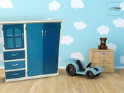 La imagen muestra el Roperito Infantil Modelo ISAAC en un encantador entorno decorado con tonos celestes y nubes, ideal para habitaciones de niño. Su estructura blanca combina perfectamente con los cajones y puertas en azules intensos, mientras que los tiradores celestes aportan un toque alegre y moderno que armoniza con el resto del mobiliario.