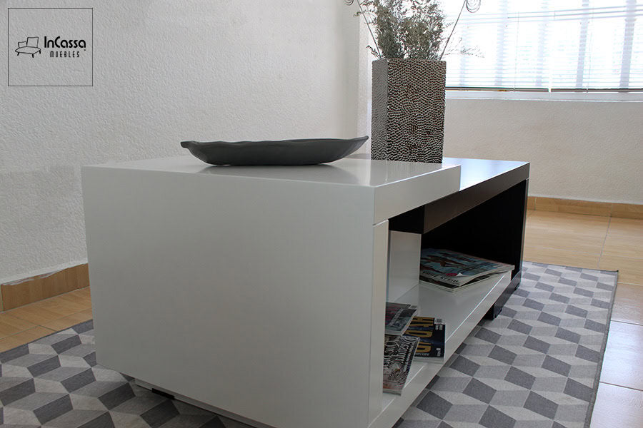 La imagen muestra el costado izquierdo de la mesa de centro ISLANDIA, donde se aprecia con claridad el contraste entre el módulo blanco elevado y la estructura principal en negro. La toma también permite observar los estantes inferiores, ideales para organizar revistas u objetos decorativos.