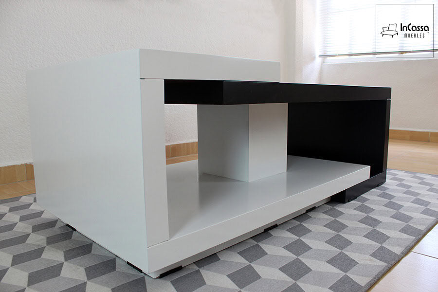 La fotografía, tomada desde un ángulo inferior, resalta la sensación de volumen y ligereza del modelo ISLANDIA. Se aprecian claramente los bordes rectos del módulo blanco envolvente, así como la separación visual del tablero negro, que genera un atractivo contraste contemporáneo sobre la alfombra tridimensional.