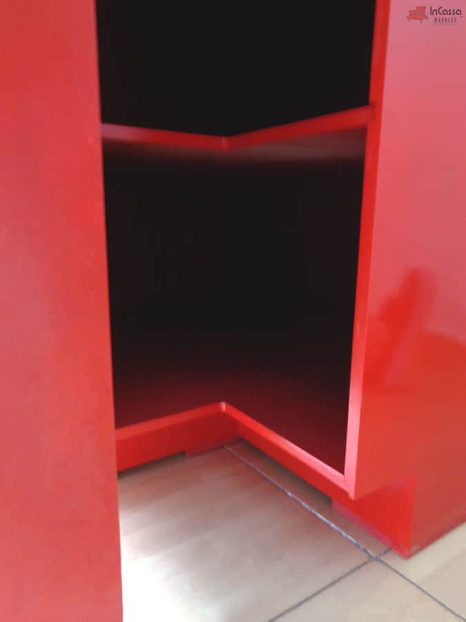 Vista cercana de la parte inferior del módulo esquinero, mostrando el acabado interno en rojo y la estructura exterior en rojo brillante. El diseño con entrepaño intermedio optimiza el almacenamiento, mientras que la base elevada facilita la limpieza y evita el contacto directo con el suelo.