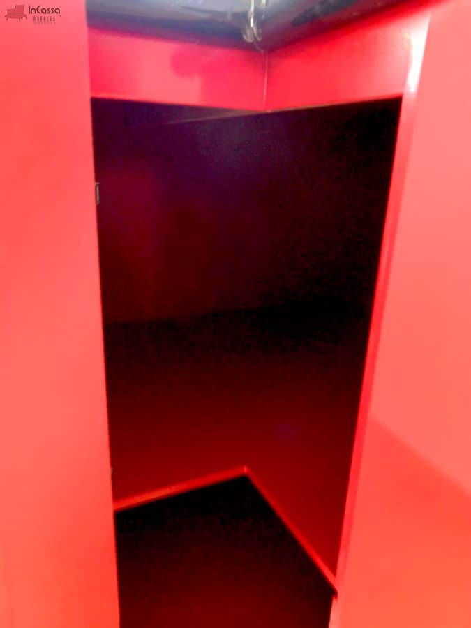 Toma cercana que muestra el interior del módulo esquinero Italia con acabado interno en color rojo, resaltado por la estructura exterior en rojo brillante. La cubierta superior de formaica estilo mármol negro con salpicadera y la amplitud interna lo convierten en una opción funcional para almacenar utensilios o accesorios de cocina.