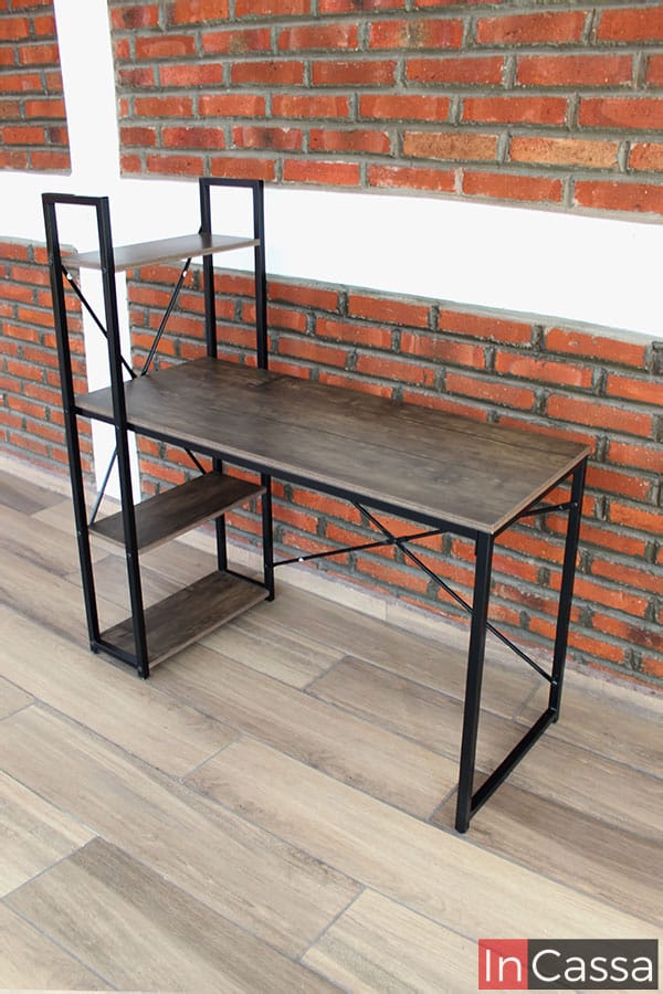 Una foto en una toma lateral del escritorio la cuál nos permite ver completa y detalladamente todo el mueble, enseñándonos cada parte de la base metálica negra así como de las superficies fabricadas de MDF en acabado laqueado.