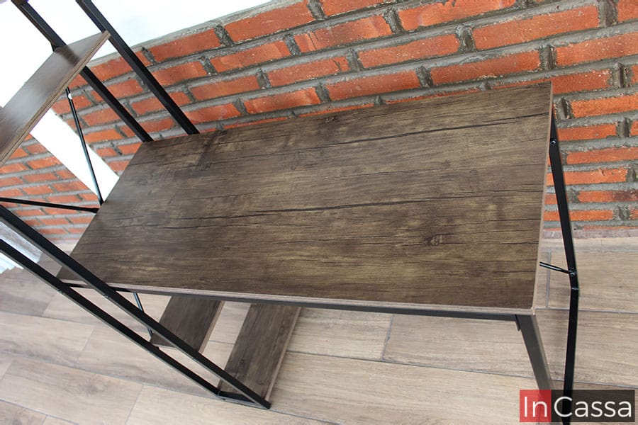 La foto destaca la longitud de la cubierta del escritorio que, al ser la parte de MDF más grande del mueble, permite ver más a detalle la calidad del material así como de su acabado laqueado. Además también se pueden ver parte de las repisas laterales izquierdas del escritorio, la cuales comparten el mismo acabado que la cubierta.