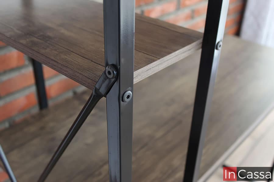 La foto se concentra en las barras con las que esta construida la estructura del escritorio, las cuales están fabricadas de metal en color negro, mismas que están unidas con tornillos a las repisas de MDF laqueado.