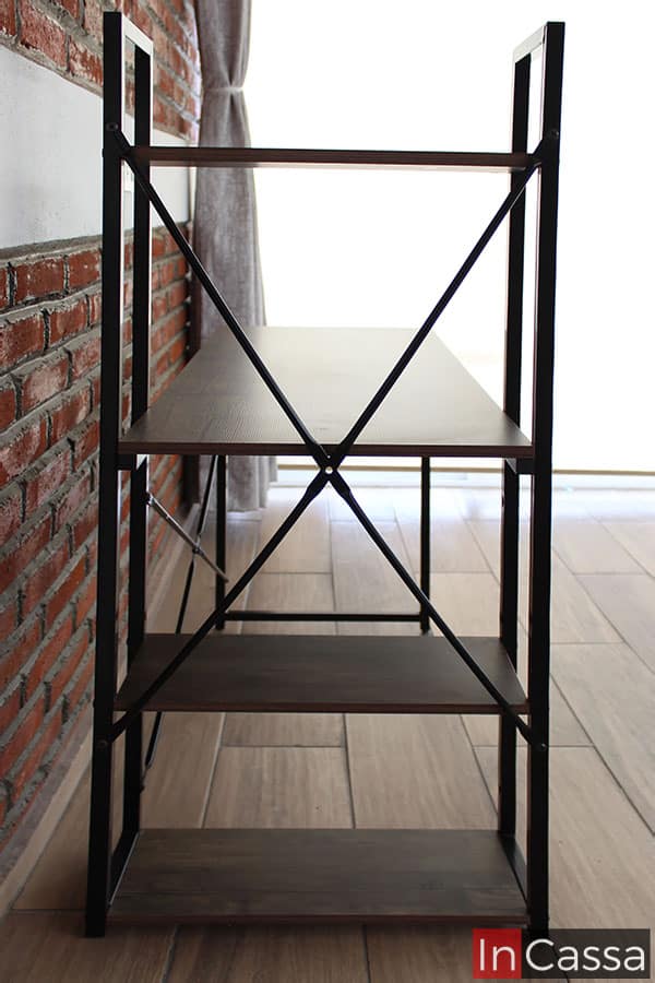 Está toma lateral da una vista completa de la estructura con repisas integrada al escritorio, la cuál sostiene parte de la cubierta del mueble y tres repisas, todas fabricadas en MDF en un acabado laqueado.