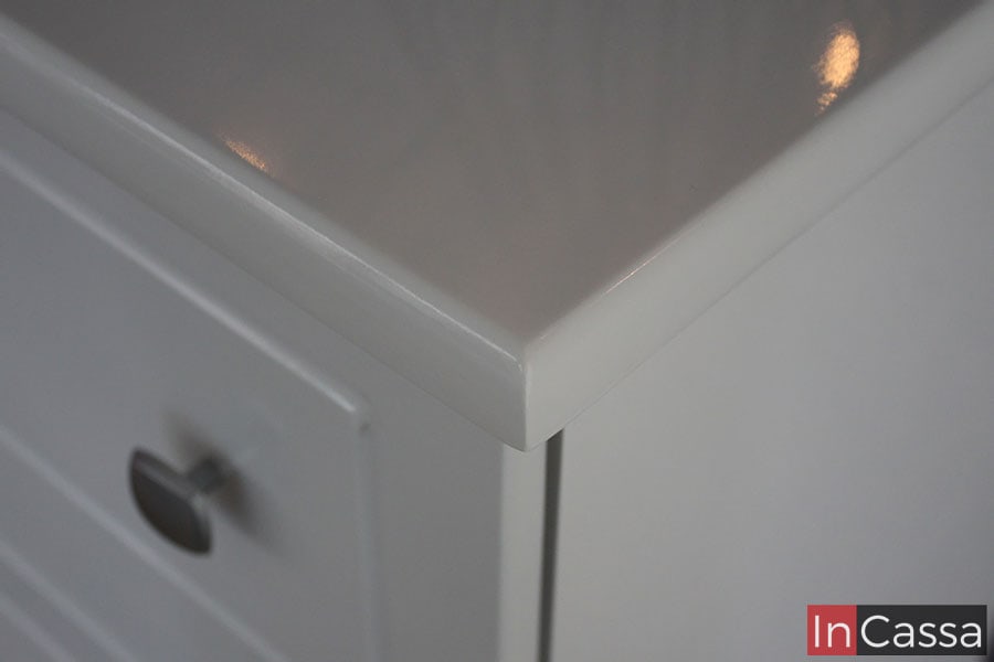 Foto de los finos bordes en la cubierta de la cajonera infantil, la cuál además destaca el acabado brillante de la pintura blanca que puede apreciarse en la totalidad del mueble.