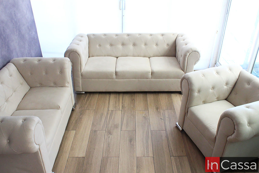 La fotografía muestra la Sala estilo Glam Modelo KÍROV tapizada en suede hueso en configuración 3-2-1, destacando su elegante capitonado, brazos curvos y diseño sofisticado que aporta amplitud, confort y armonía visual al espacio.