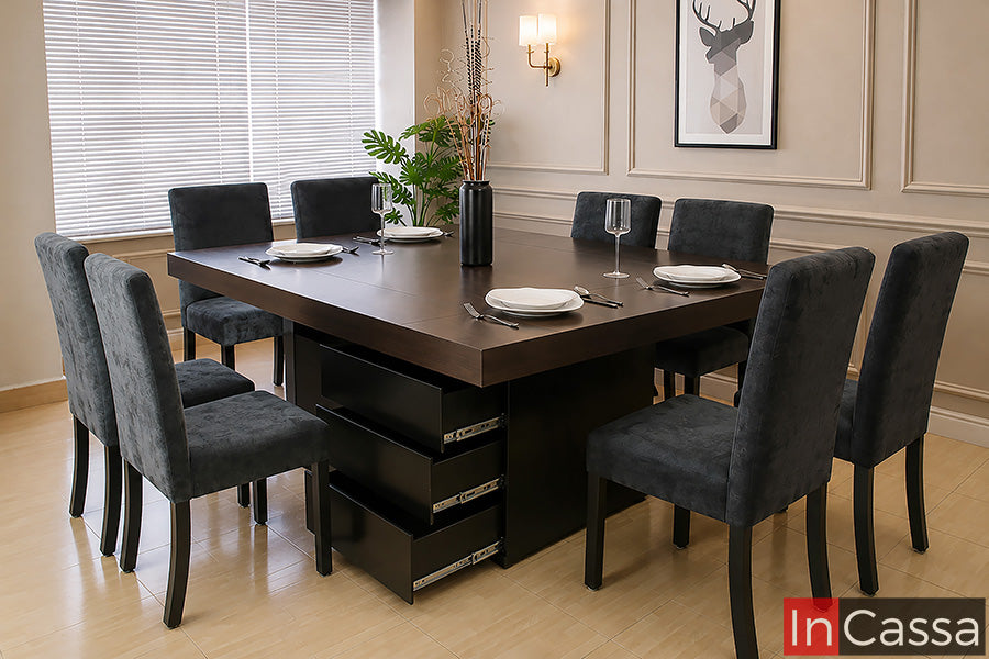 Se muestra el Comedor Modelo LEÓN para 8 personas con cubierta en acabado tabaco, pedestal color chocolate y sillas tapizadas en suede gris oxford, un diseño de estilo contemporáneo que combina elegancia, amplitud y funcionalidad. Su robusta cubierta ofrece un amplio espacio para convivir cómodamente, mientras que el pedestal con cajones integrados brinda almacenamiento práctico y las sillas tapizadas proporcionan un alto nivel de confort para disfrutar cada reunión.