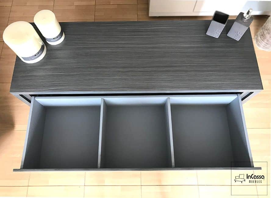 La imagen resalta el diseño interior del tocador, con divisiones en los cajones que facilitan la organización de prendas y accesorios de manera ordenada y práctica. El tocador se presenta en acabado gris cenizo oscuro completo.