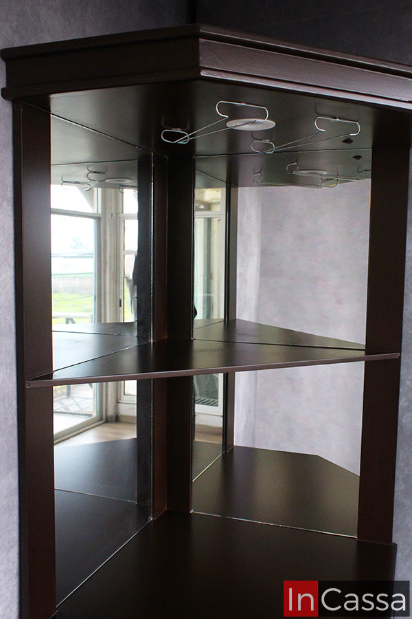 En primer plano, la Cantina Modelo LILIAN en acabado tabaco resalta por sus espejos interiores, entrepaños y colgadores para copas, diseñados para exhibir tu cristalería con elegancia. Un mueble funcional que aporta amplitud visual y un toque sofisticado a cualquier ambiente.
