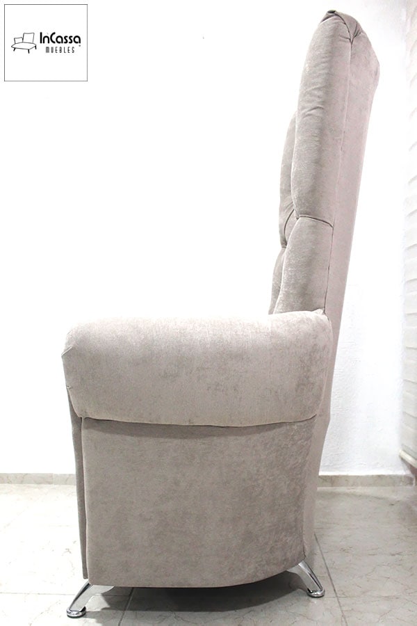 Desde esta vista lateral, se aprecia la imponente altura del respaldo, diseñado para brindar máximo soporte y comodidad. Su tapizado en tela suede gris perla complementa su estilo elegante, mientras que las patas cromadas inclinadas añaden estabilidad y un toque moderno.