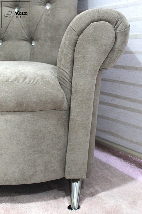 El diseño clásico de este sillón resalta con su brazo acolchado en elegante forma curva. Su tapizado en tela suede gris perla aporta calidez, mientras que la pata metálica cromada añade un toque moderno y sofisticado.
