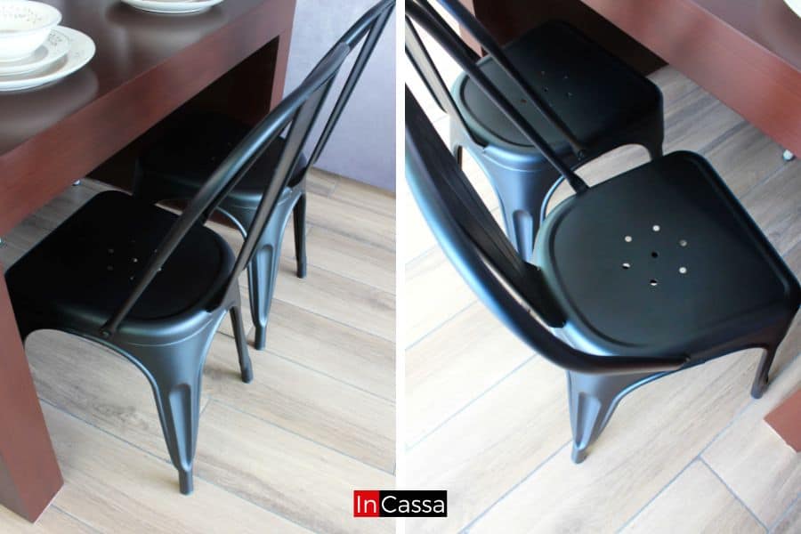 Elegantes sillas metálicas en negro mate, que complementan la mesa con un toque industrial. El diseño ergonómico y el respaldo curvo proporcionan comodidad y estilo al mismo tiempo.