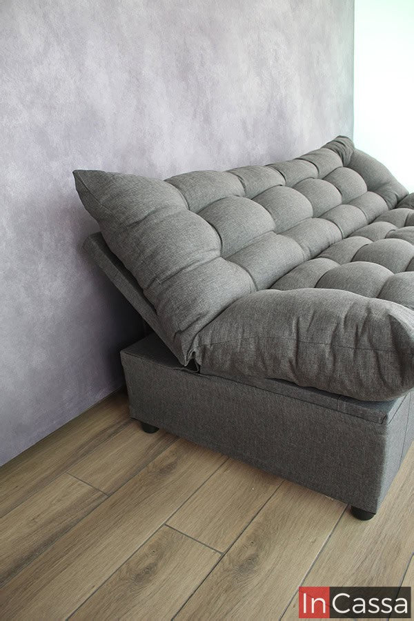 La imagen se concentra en ejemplificar el funcionamiento del mecanismo de inclinación y declinación del respaldo del sofá cama, el cuál vemos en una posición inclinada. Además también podemos observar que el mueble entero mantiene el tapizado lino estilo mouse en su totalidad.