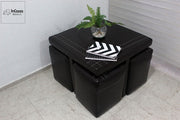 La imagen destaca el diseño compacto y funcional de la mesa de centro con taburetes incluidos, ideal para espacios pequeños. Su acabado en tacto piel negro y costuras decorativas aporta un toque elegante, perfecto para ambientes contemporáneos.