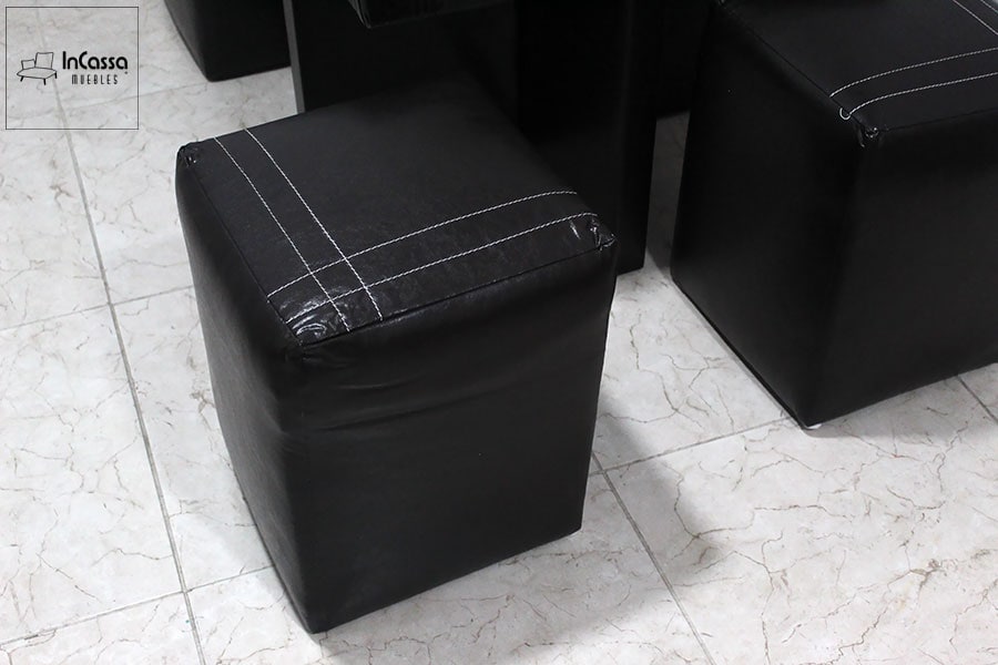 Esta foto se centra en los taburetes de la mesa Luarca, mostrando su diseño ergonómico y tapizado en tacto piel negro. Ideales para proporcionar un asiento cómodo en un formato compacto.